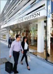  ?? THE ASSOCIATED PRESS ?? Shoppers walk past the Louis Vuitton store on Rodeo Drive in Beverly Hills, Calif.