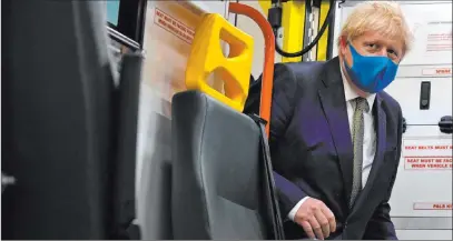  ?? Ben Stansall The Associated Press ?? Britain’s Prime Minister Boris Johnson boards an ambulance Monday during a visit to the headquarte­rs of the London Ambulance Service NHS Trust. The British government decided Monday to require people to wear face coverings in shops.