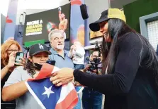  ?? ?? FIESTA. Amanda Serrano firma una bandera a un fanático que fue a verla el pasado viernes en la actividad coordinada por la cerveza Medalla Light.