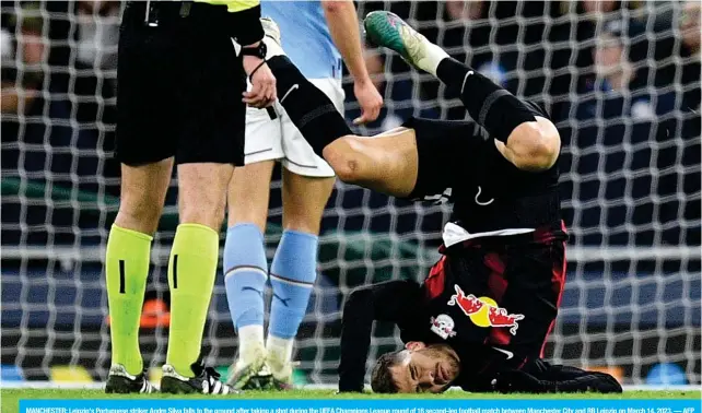  ?? — AFP ?? MANCHESTER: Leipzig’s Portuguese striker Andre Silva falls to the ground after taking a shot during the UEFA Champions League round of 16 second-leg football match between Manchester City and RB Leipzig on March 14, 2023.