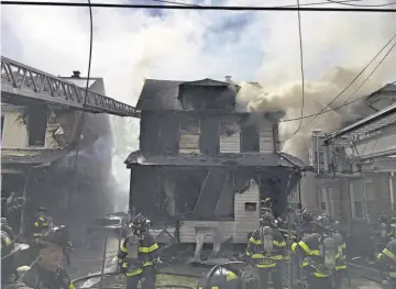  ??  ?? Tragedia. Bomberos tratan de extinguir un incendio en Queens Village, Nueva York. Cinco personas de una misma familia, incluidos tres niños, murieron en el incendio.