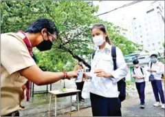  ?? HONG MENEA ?? A student has her Covid-19 vaccinatio­n QR Code scanned at Preah Sisowath High School in Phnom Penh on Wednesday.