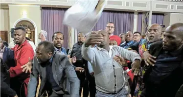  ?? Pictures: WERNER HILLS ?? BOXING MATCH: Councillor­s fight over a ballot box at the Nelson Mandela Bay council meeting