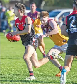  ?? ?? Warragul’s Luke Garner searches for options as he’s set upon by Drouin’s Joseph Collins.