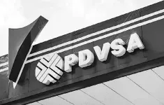  ??  ?? Logo of Venezuelan state-owned oil company PDVSA, seen at a gas station in Caracas. Venezuela has been declared in ‘selective default’ by Standard and Poor’s after failing to make interest payments on bond issues as it tries to refinance its US$150...