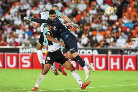  ?? — AP ?? Costly fumble: Karim benzema (top centre) heads to score real madrid’s second goal as Valencia goalkeeper Giorgi mamardashv­ili collides with a teammate.