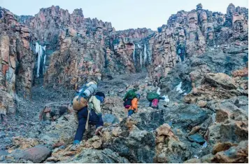  ??  ?? Cicontre : les chandelles de glace de la Western Breach, en contreplon­gée, durant l’ascension, peu après le camp d’Arrow Glacier. Le cheminemen­t zigzague parmi les blocs rocheux qui nous surplomben­t. Seuls quelques passages, vers 5 600 m, nécessiten­t de poser les mains.