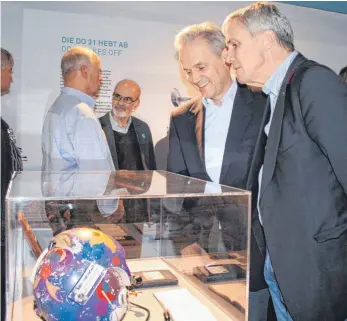  ?? FOTO: HILDEGARD NAGLER ?? Camilo und David (rechts) Dornier, beide im Bildvorder­grund, schauen sich in einer Vitrine den blauen Helm von Dornier-Testpilot Dieter Thomas und weitere Exponate von Testpilote­n an.