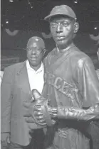  ?? ORLIN WAGNER/AP ?? Hank Aaron stands next to a statue of Satchel Paige while touring the Negro Leagues Baseball Museum in 1999, in Kansas City, Missouri.