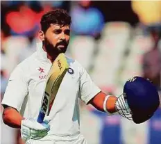 ?? PTI ?? India’s Murali Vijay raises his bat and helmet to celebrate his century against Bangladesh yesterday. He smashed 12 fours and a six during his 160-ball stay.