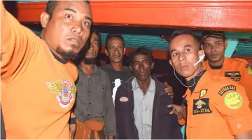 ??  ?? This picture shows Indonesian rescuers flanking two men (second left and third right), part of a group of five Rohingya Muslims rescued by Indonesian fishermen after they were stranded at sea for almost almost three weeks, in Banda Aceh. — AFP photo