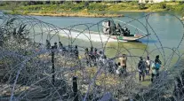  ?? ERIC GAY/ASSOCIATED PRESS FILE PHOTO ?? Migrants who crossed into the U.S. from Mexico in September are met with concertina wire in Eagle Pass, Texas. The 2023 fiscal year set a record for illegal border crossings.