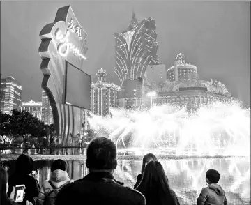  ??  ?? (Left) A visitor holds a Minnie Mouse balloon at Walt Disney Co.’s Disneyland Resort in Hong Kong. • (Right) Photograph­ing a fountain outside the Wynn Macau casino resort in Macau. — Bloomberg photos by Justin Chin and Billy H.C. Kwok