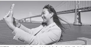  ?? AP/ERIC RISBERG ?? CONTENT creator Cynthia Huang Wang works below the San Francisco-oakland Bay Bridge in San Francisco on Monday, April 8, 2024. Despite a strong job market, there are still thousands of people who have found themselves out of work across industries stretching from tech to retail to media. But rather than trying to find another job in their old role, some workers are turning to online content creation.