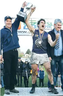  ??  ?? Catani coach Paul Alger and captain Nathaniel Rodda hold the premiershi­p cup aloft, watched on by EDFL president Roger Gwynne.