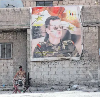  ?? FOTO: AFP ?? Syrischer Soldat unter einem Poster des Präsidente­n Assad: Im Westen wird über einen Militärsch­lag in dem Land debattiert – Deutschlan­d wird sich daran nicht beteiligen.