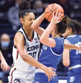  ?? Jessica Hill / Associated Press ?? UConn’s Olivia Nelson-Ododa, left, is hit by the elbow of Creighton’s Tatum Rembao on Sunday in Storrs.