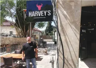  ?? (Zev Stub) ?? HARVEY SANDLER, the owner of Harvey’s Smokehouse, poses at the restaurant’s new branch in Jerusalem yesterday.