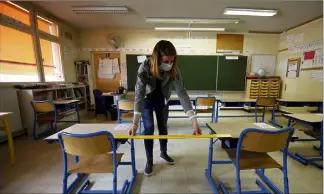  ??  ?? Céline Bentz, la directrice de l’école mentonnais­e Saint-Exupéry, réaménage sa salle de classe avant l’arrivée des premiers élèves jeudi. (Photos Jean-François Ottonello)