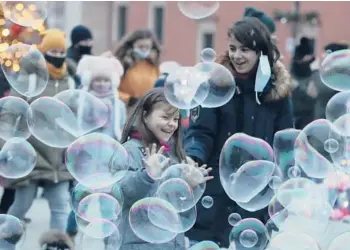  ?? CZAREKSOKO­LOWSKI/AP ?? Playtimeam­idthepande­mic: People try to maintain social distance to prevent the spread ofCOVID-19 Saturday as they play with soap bubbles in Castle Square inWarsaw, Poland. The country has logged more than 1.3 million confirmed coronaviru­s infections and more than 29,000deaths fromCOVID-19, according toJohns Hopkins University data.