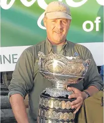  ??  ?? Scottish National trout fly fishing champion Brian Mackenzie with the trophy.