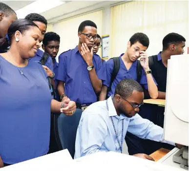  ?? GLADSTONE TAYLOR/ PHOTOGRAPH­ER ?? Jamaica College Teacher of the Year Latoya Cousins (left) touring The Gleaner Company (Media) Limited at North Street, Kingston, with some of her students yesterday. Ahon Gray (seated), photo research assistant, demonstrat­es to the students accessing...
