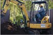  ?? ?? Left to right, Santos Excavating employees Brandon Braty, Angel Orozco and Humberto Orozoco in the excavator work together on grading and undergroun­d work Wednesday for the Everhart Village emergency shelter project in Chico.