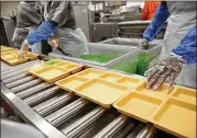  ?? ROSE BACA / DALLAS MORNING NEWS ?? Inmates serve pineapple and lime gelatin at the Lew Sterrett Justice Center in Dallas. Low-level inmates known as trusties prepare food for the Dallas County adult and juvenile facilities.