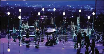  ??  ?? Musician John Legend (center) performs onstage.
