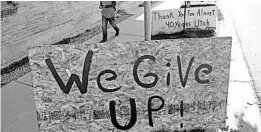  ?? RICK BOWMER/AP ?? A man walks past a “we give up” sign outside Euro Treasures Antiques on Friday in Salt Lake City, where the proprietor is closing his art and antique store after 40 years.