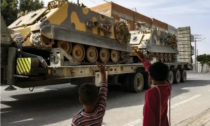  ??  ?? Children wave to a Turkish forces truck at the border with Syria in south-eastern on Turkey. Photograph: Emrah Gürel/AP