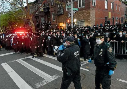  ?? AP ?? Police tell a crowd crowd to disperse as hundreds of mourners gather in the Brooklyn borough of New York, to observe a funeral for Rabbi Chaim Mertz, a Hasidic Orthodox leader whose death was reportedly tied to the new coronaviru­s.