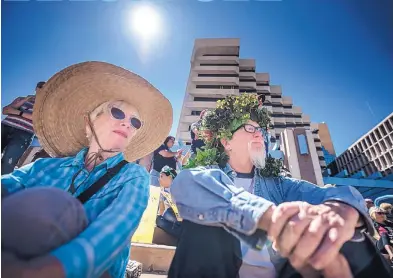  ?? ROBERTO E. ROSALES/JOURNAL ?? Edie Scott, left, and Richard Tuthill listen to scientists speak to the crowd during the Albuquerqu­e Earth Day celebratio­n and March for Science Saturday in Downtown. Many came holding signs or wearing costumes recognizin­g Mother Earth.