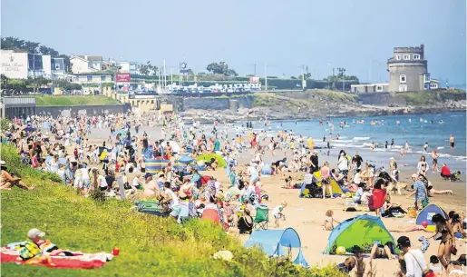  ?? PHOTO: GARETH CHANEY ?? Sun, sea and sand: People enjoying the good weather on Portmarnoc­k Beach in Dublin yesterday.