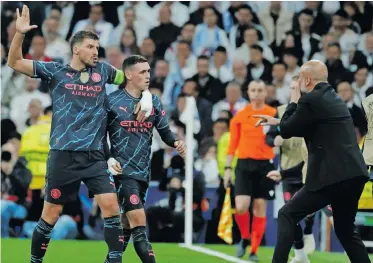  ?? ?? MANCHESTER City boss Pep Guardiola (right) celebrates with Phil Foden (centre), who scored the equaliser against Real Madrid on Tuesday. | EPA