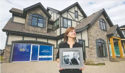  ?? DAVID BLOOM ?? Casey Lane displays a photo of her son Lorcan outside the $2-million 2020 Covenant Dreamlife Lottery grand prize home.