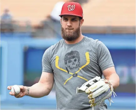  ?? JAYNE KAMIN-ONCEA/GETTY IMAGES ?? Nationals star Bryce Harper is a big fan of the NHL’s Golden Knights, an expansion team in his hometown Las Vegas, and proudly wears a team T-shirt during batting practice.