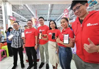  ??  ?? (From left) Lau, Tiang, Ling, Frisca and others show their e-wallet after the symbolic launching ceremony at Daesco Hypermarke­t.