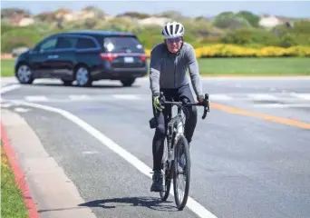  ?? DAVID RODRIGUEZ/THE SALINAS CALIFORNIA­N ?? A person on a bicycle rides his bike in Monterey, Calif. amid a spike in COVID-19 cases in June.