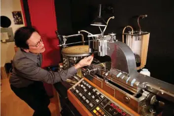  ?? Allen J. Schaben/Los Angeles Times ?? Bernie Grundman, a veteran mastering engineer, shows off his system for cutting master disks for vinyl production. The rise of vinyl has been a boon for business.