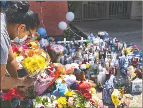  ?? (AP/Richard Vogel) ?? A woman leaves flowers at a memorial for the children who were killed at the Royal Villa apartments complex.