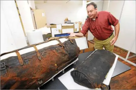  ?? PETE BANNAN — DIGITAL FIRST MEDIA ?? R. Scott Stephenson, vice president of collection­s at the Museum of the American Revolution, looks at George Washington’s portmantea­u, a suitcase used during the Revolution­ary War. It is printed with “Height Dorchester 1775” and “Battle of Yorktown...