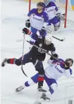  ?? AP PHOTO ?? BODY OF WORK: Team USA’s Chris Bourque, the son of former Bruins great Ray Bourque, hammers Marek Hovorka of Slovakia during preliminar­y round play last week.