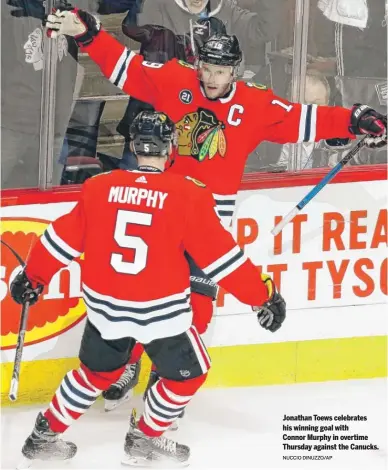  ?? NUCCIO DINUZZO/AP ?? Jonathan Toews celebrates his winning goal with Connor Murphy in overtime Thursday against the Canucks.
