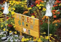  ??  ?? ABOVE: The Project Grow Love memorial garden at Marjory Stoneman Douglas High School in Parkland, Fla., has stones with the names of each of the 17 people killed in the 2018 Valentine’s Day mass shooting.BELOW: Many supportive signs still surround the school, and many Parkland students have become advocates for gun control legislatio­n and getting young people to vote.