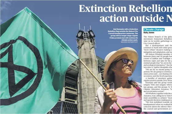  ?? BRADEN FASTIER/STUFF ?? Ami Kennedy with a Extinction Rebellion flag outside the Nelson City Council headquarte­rs yesterday. The group will no longer stage regular Friday protests but will continue its climate action work.