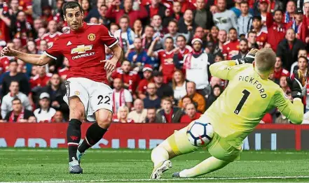 ?? — Reuters ?? Neat finish: Manchester United’s Henrikh Mkhitaryan scoring the second goal past Everton goalkeeper Jordan Pickford in the English Premier League match at Old Trafford yesterday. United won 4- 0.