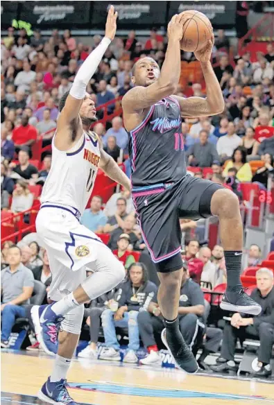  ?? JOHN MCCALL/SUN SENTINEL ?? Heat guard Dion Waiters beats Nuggets guard Monte Morris to the basket Tuesday night at AmericanAi­rlines Arena.