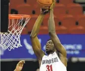  ?? K.C. ALFRED U-T ?? San Diego State’s Nathan Mensah slams the ball for two of his 10 points Saturday against Utah State.