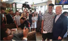  ??  ?? Joe Biden takes a photo with a guest at Detroit One Coney Island Restaurant on Thursday. Photograph: Scott Olson/Getty Images